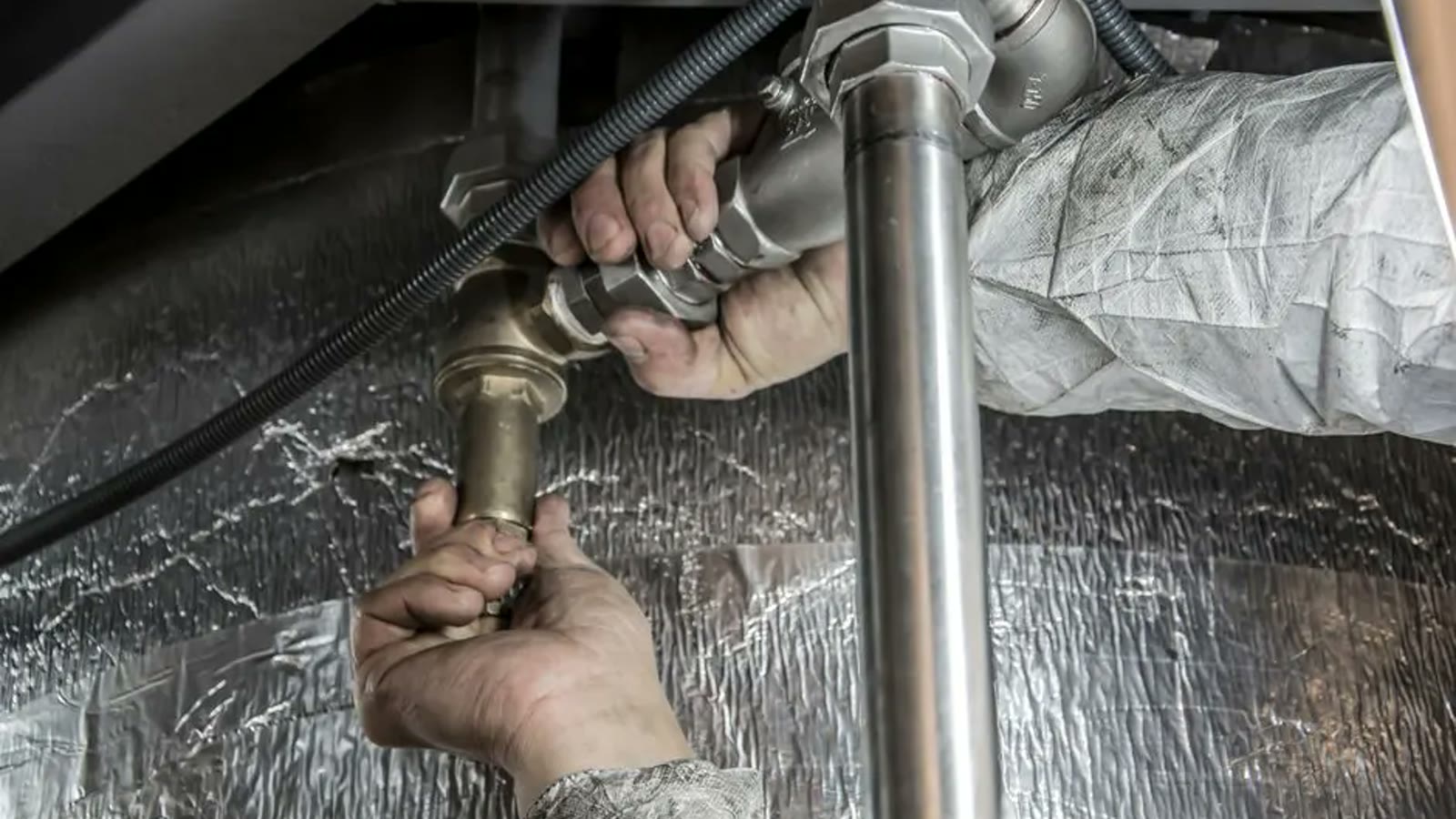 Plumber explaining a pipe connection in a Chandler home